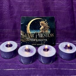 Four lit purple tealight candles sit in a row on a purple cloth in front of a “Lunar Priestess Tea Lights – Sage Goddess” card showing a woman seated in a crescent moon.